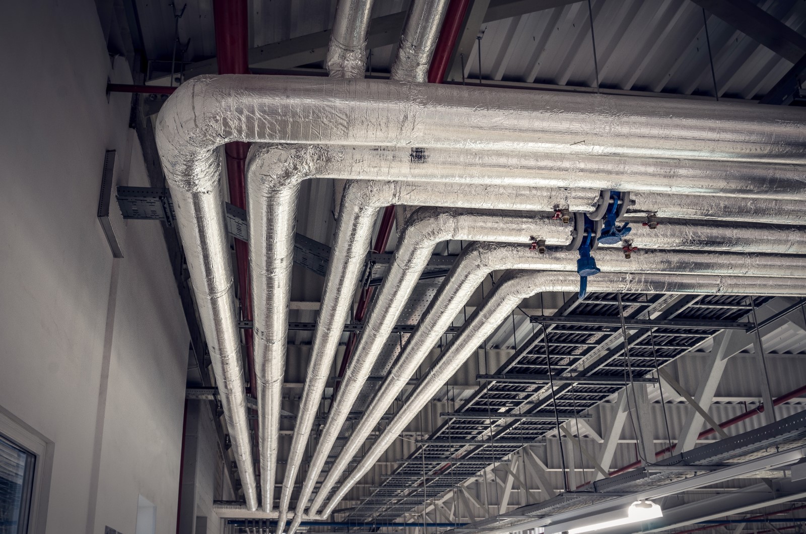 Proper mechanical insulation design around metal pipes provides optimal energy conservation in an industrial building.