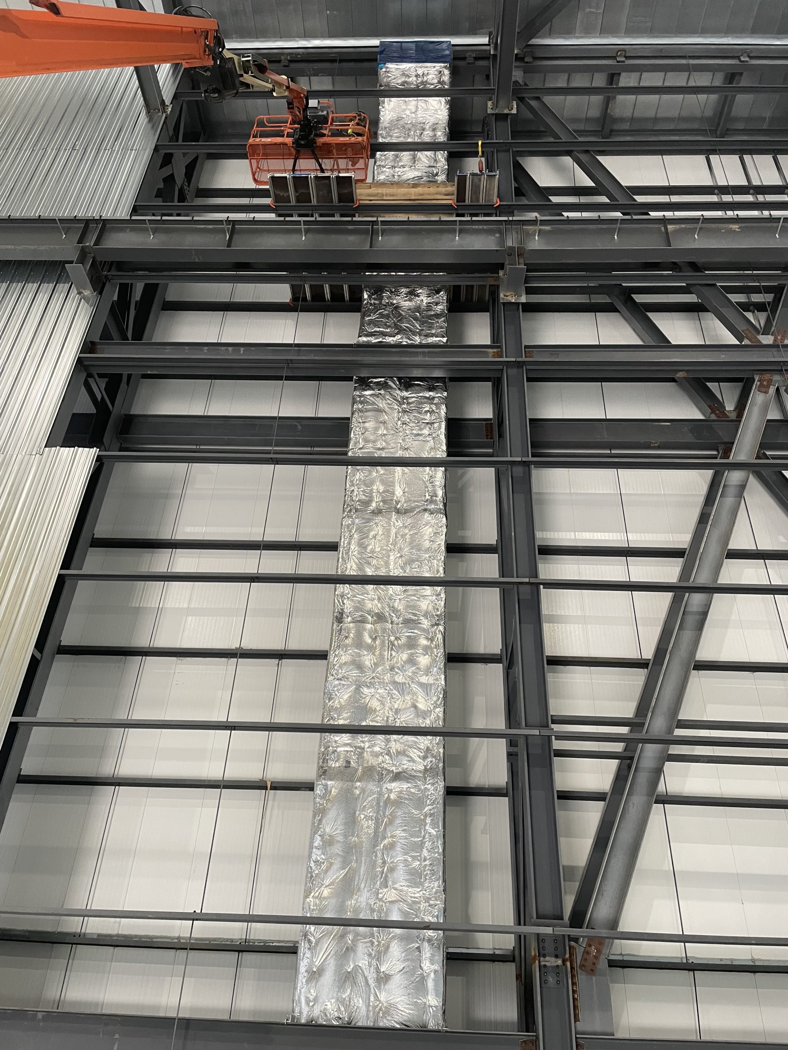 Custom scaffolding solution allows worker to insulate industrial ductwork 150-ft-tall
